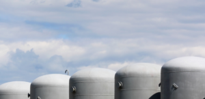 Hydrogen storage tanks with cloudy blue sky in the background