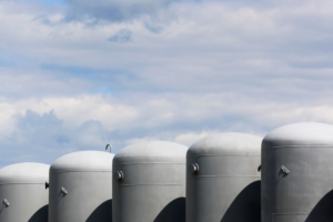 Hydrogen storage tanks with cloudy blue sky in the background