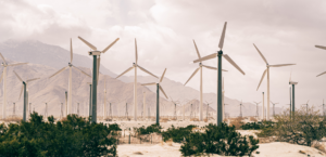 Wind turbines in a desert field against a grey sky